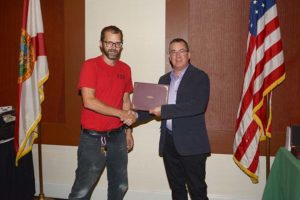 Two men shaking hands during certificate presentation