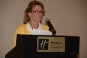 Woman speaking at Holiday Inn podium