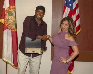 Two people shaking hands with certificate