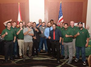 Group of men giving thumbs up with flags