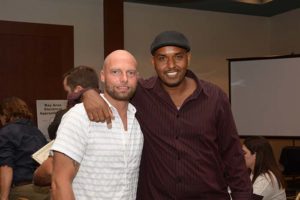 Two men smiling with arm around shoulders