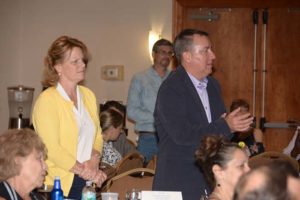 Man speaking while woman listens at conference