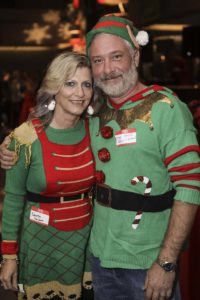 Smiling couple in matching Christmas elf sweaters