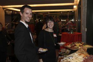 Two guests smiling at party appetizer buffet