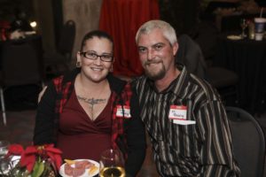 Two people smiling at a dinner table