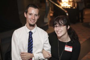 Man and woman smiling at social event