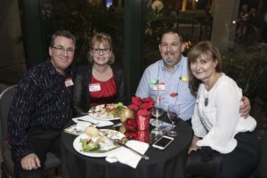 Four adults smiling around a dinner table
