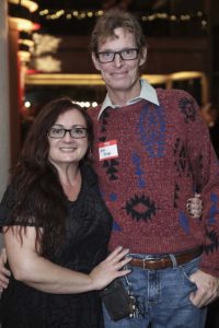 Smiling couple wearing glasses at indoor event