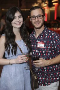 Smiling couple holding drinks at party