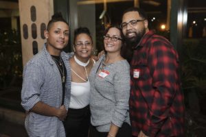 Four people smiling at social event