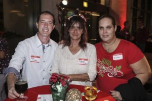 Three people at holiday party with drinks
