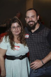 Two smiling people wearing name tags indoors