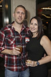 Two people smiling and holding drinks