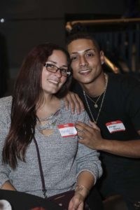 Two smiling people wearing name tags at event