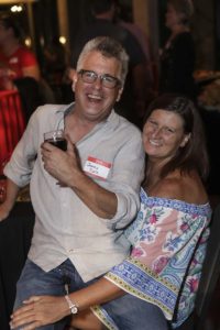 Smiling couple at party, man holding wine