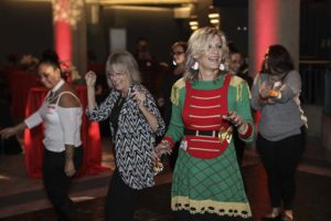 People dancing at party, woman wearing elf costume