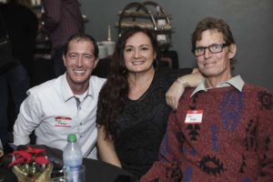 Three people smiling at a social event
