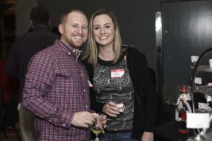 Smiling couple holding drinks at holiday gathering