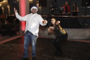 Man wearing Santa hat dancing at holiday party