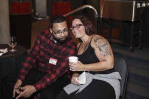 Smiling man and tattooed woman at event