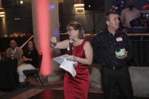 Woman in red dress speaking at event