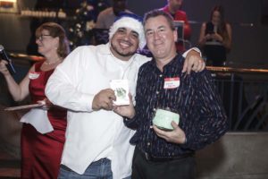 Two men smiling at holiday party