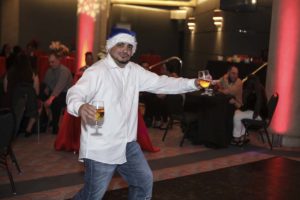 Man in Santa hat holding two beers