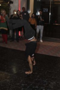 Breakdancer performing handstand amid cheering party crowd