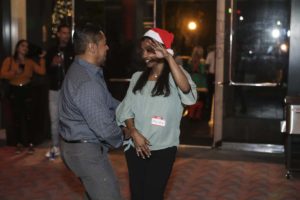 Couple dancing, woman wearing Santa hat