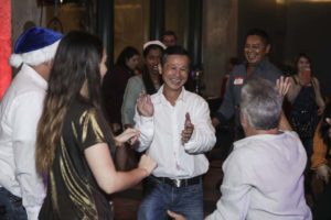Smiling adults dancing together at lively party