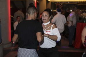 Two people dancing at crowded indoor event