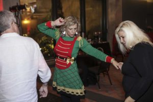 Woman dancing in green Christmas elf dress