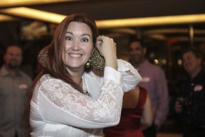 Smiling woman holding sparkly ornament at party