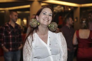 Smiling woman wearing oversized glittery ornament earrings