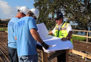 Construction workers reviewing blueprints on site