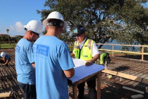 Construction crew reviewing blueprints at waterfront