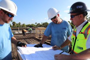 Construction workers reviewing blueprints on site