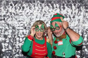 Couple wearing Christmas sweaters and novelty glasses
