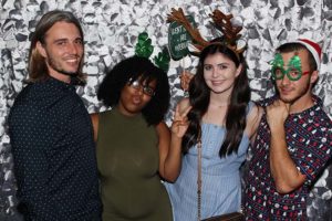 Four friends posing with holiday photo props