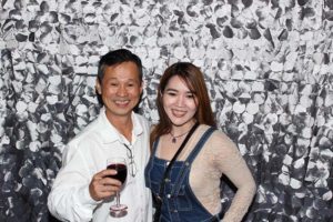 Smiling pair posing, man holding wine glass