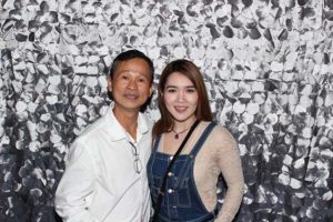 Man and woman smiling against silver petal backdrop
