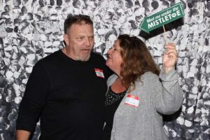 Couple posing with mistletoe sign