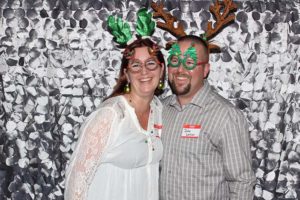 Smiling couple wearing reindeer antlers and glasses