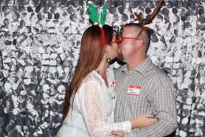 Couple kissing wearing reindeer antlers and glasses