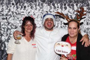 Three people in Christmas hats and antlers