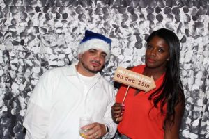 Man in Santa hat and woman holding sign