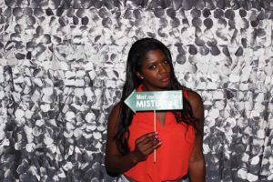 Woman in red top holding mistletoe sign