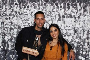 Couple smiling in front of silver sequin backdrop