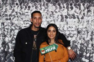 Man and woman posing with "elfie" sign