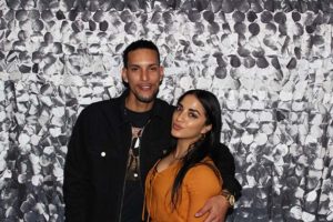 Man and woman posing by silver sequin backdrop